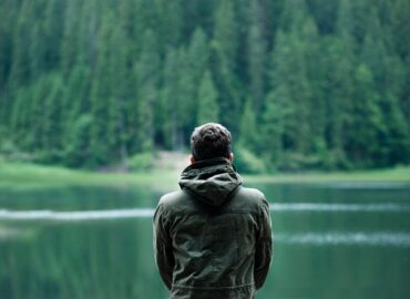 man staring into lake