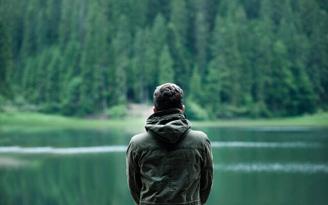 man staring into lake