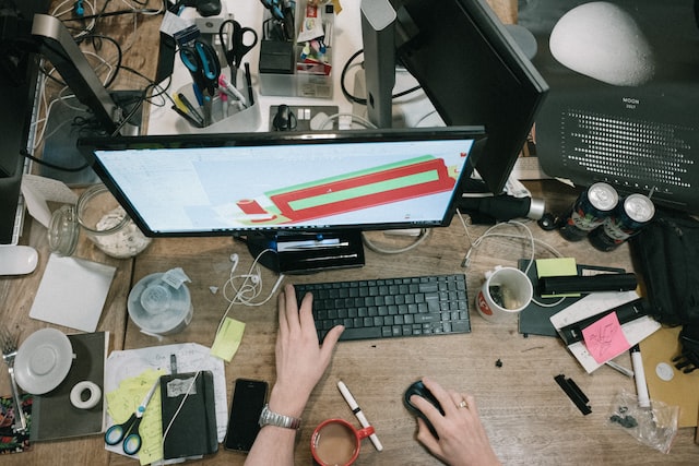 person using a computer with a messy desk