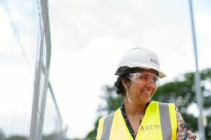 smiling woman wearing helmet and hi vis vest